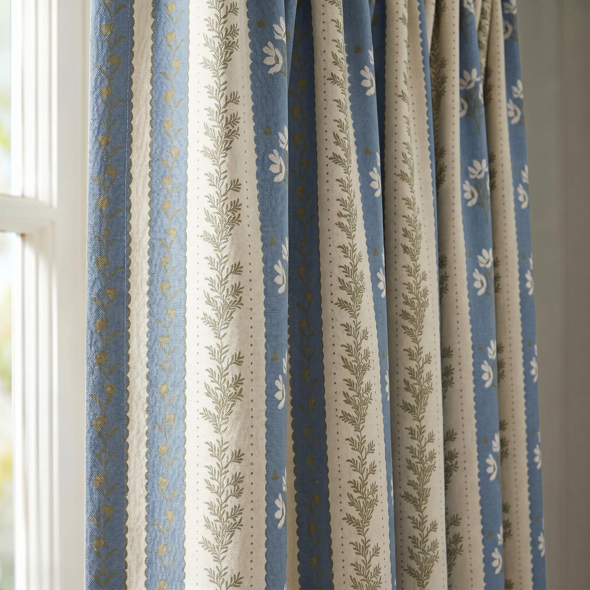 Botanical stripe curtain fabric with leafy green vines and coral flowers.