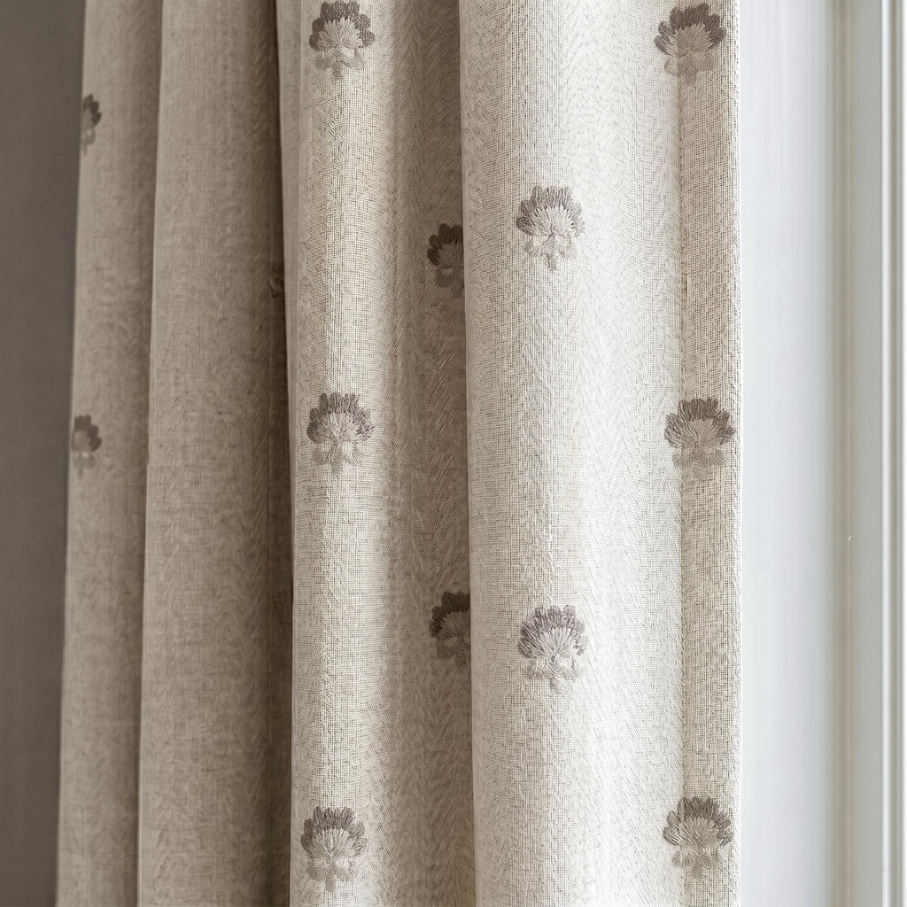 Textured beige curtains with taupe floral embroidery.